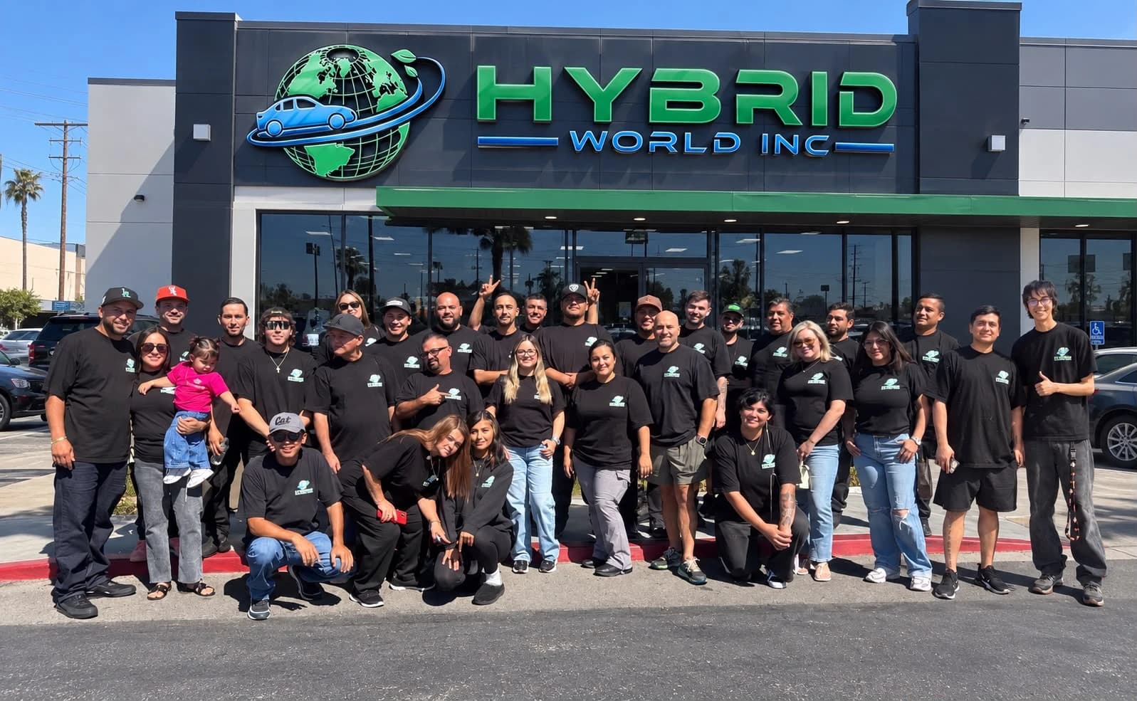 The Hybrid World team in company shirts in front of the Hybrid World Inc storefront